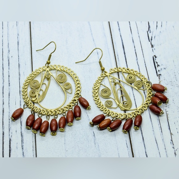 Gold tone hoop earrings with dangling wood beads. - Picture 2 of 2